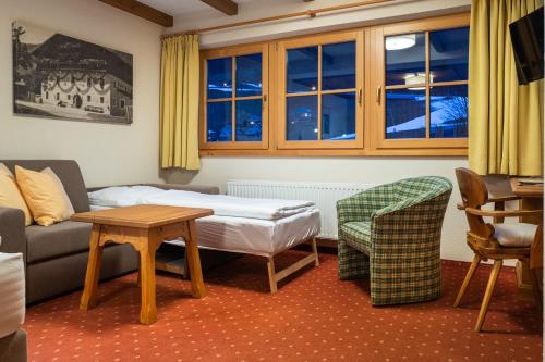 a living room with a couch and a table at Hotel Senningerbräu in Bramberg am Wildkogel