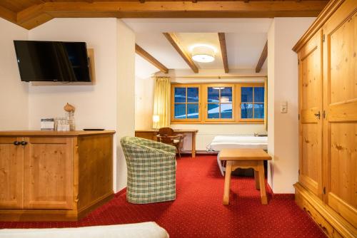 a hotel room with a bed and a tv at Hotel Senningerbräu in Bramberg am Wildkogel