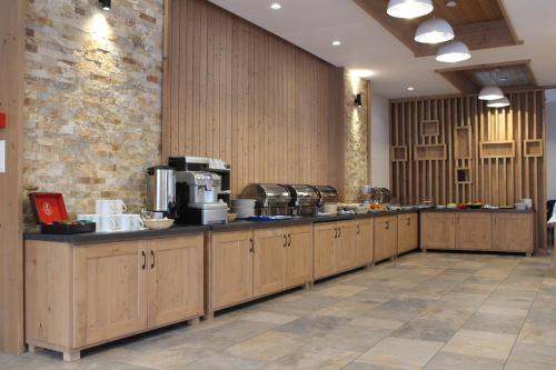 a large kitchen with wooden cabinets in a room at Monte Cervo Bio Hotel & Spa in Covasna