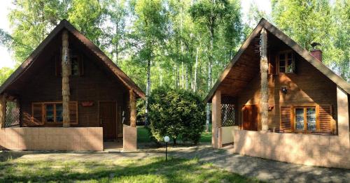 una pequeña casa de madera frente a algunos árboles en Zakatek Kliczkow, en Osiecznica