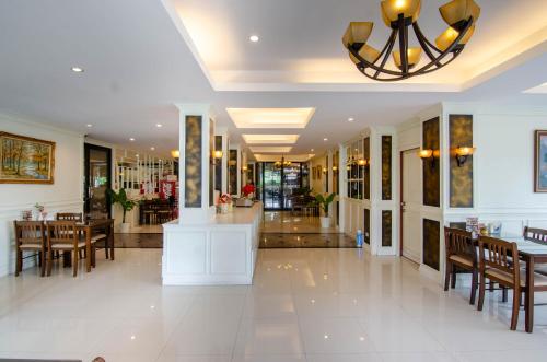 a lobby with tables and chairs and a restaurant at Tara Lake in Bangkok