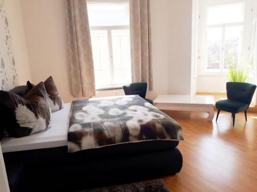 Un dormitorio con una cama con una manta. en Pension Altenburg City en Altemburgo