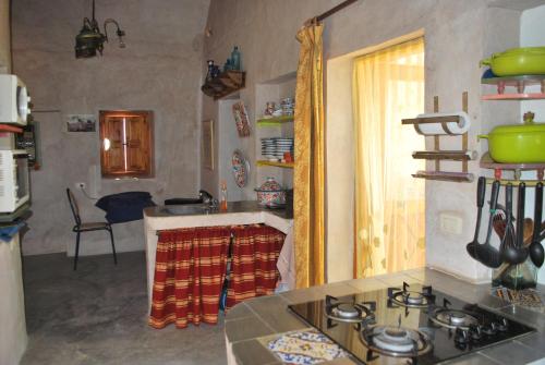 a kitchen with a sink and a stove top oven at Grand Sud, la maison de sable in Douz
