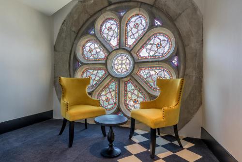 two chairs and a table in front of a window at Hotel du Roi & Spa by SOWELL COLLECTION in Carcassonne