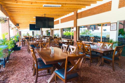 a restaurant with wooden tables and chairs and a flat screen tv at Hotel Boutique Matea in Ixtapan de la Sal
