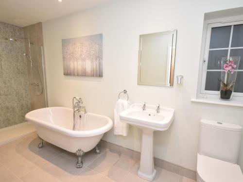 a bathroom with a tub and a sink and a toilet at Lavender Cottage in York