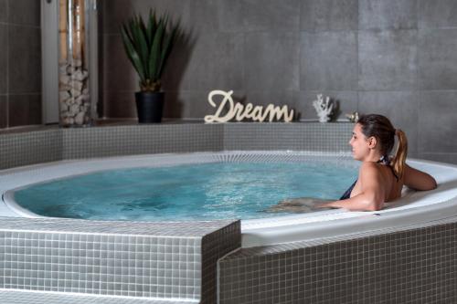 a woman is sitting in a jacuzzi tub at Hotel du Roi & Spa by SOWELL COLLECTION in Carcassonne