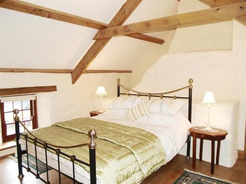 um quarto com uma cama grande e tectos em madeira em Panteurig Cottage em Goodwick