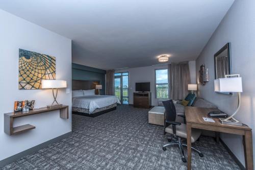 a hotel room with a bed and a desk with a desk at Staybridge Suites Charleston - Mount Pleasant by IHG in Charleston