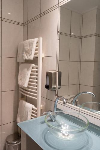a bathroom with a glass sink and a mirror at HOTEL HILL in Athens