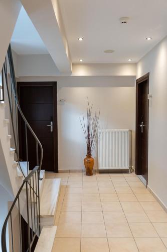 a hallway with a staircase and a vase on the floor at HOTEL HILL in Athens