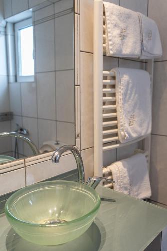 a bathroom sink with a green bowl in front of a mirror at HOTEL HILL in Athens
