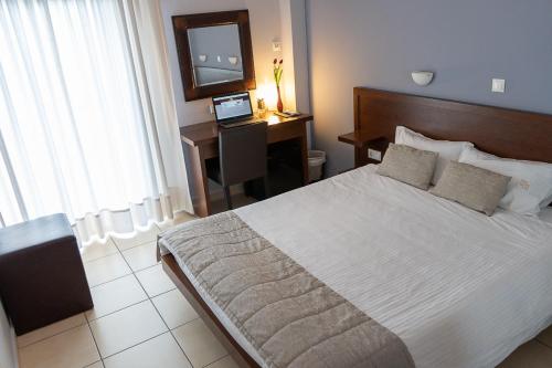 a bedroom with a bed and a desk with a laptop at HOTEL HILL in Athens
