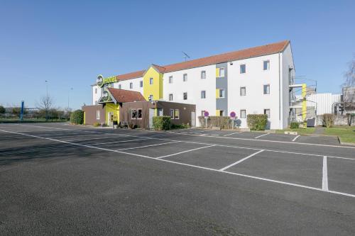 an empty parking lot in front of a hotel at B&B HOTEL Poitiers 1 Futuroscope in Chasseneuil-du-Poitou