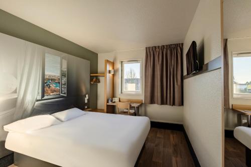 Ένα ή περισσότερα κρεβάτια σε δωμάτιο στο B&B HOTEL Poitiers 1 Futuroscope