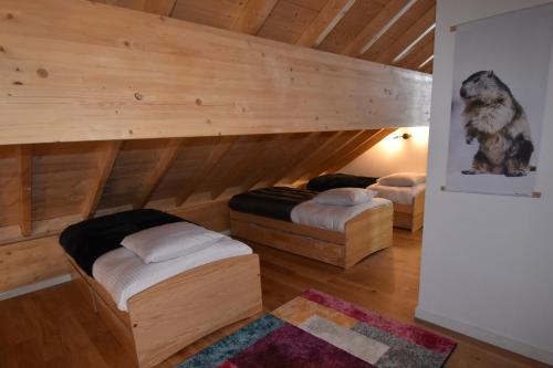 two beds in a room with wooden walls at VAUJANYLOCATIONS - Ameythistes B8 in Vaujany