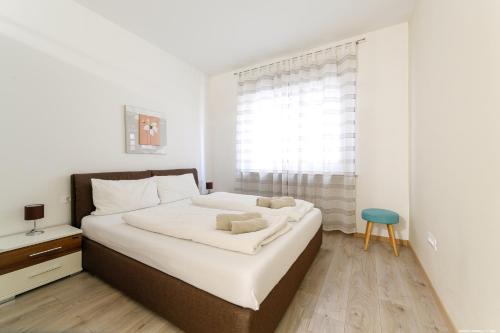 a bedroom with a bed with white sheets and a blue stool at Apartment Merano in Merano