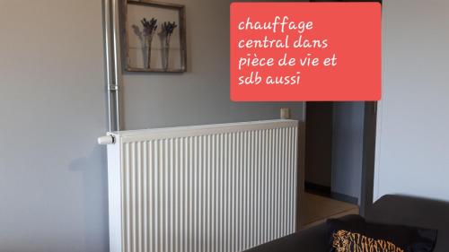 a sign in a room with a radiator at La chambre d Angeline in Foy-Notre-Dame