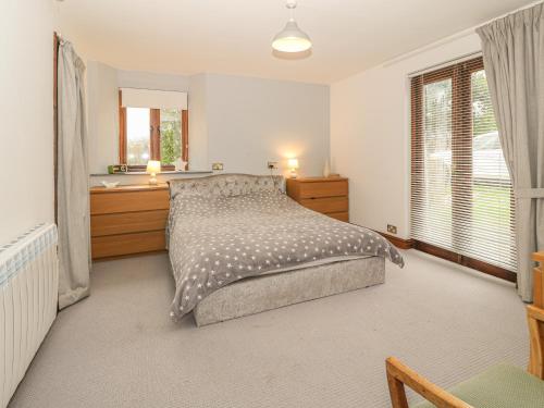 una camera da letto con un letto e una finestra di Tyn Morfa a Pwllheli