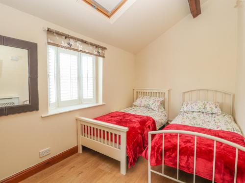 two beds in a room with a window at Heath Corner in Knutsford