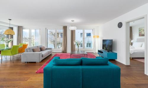 uma sala de estar com um sofá azul e uma mesa em Swiss Hotel Apartments - Interlaken em Interlaken
