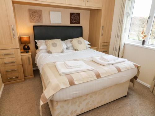 a bedroom with a large bed with two towels on it at 16 Sherwood Lodge in Carnforth