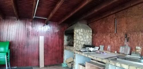 a kitchen with red walls and a stone oven at Pensiunea Vila Mocanilor in Săcele