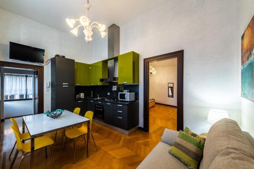 Cà Sant'Angelo في البندقية: مطبخ وغرفة معيشة مع طاولة وأريكة
