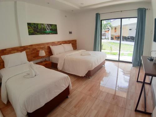 a hotel room with two beds and a window at Chinita Boutique Hotel in Panglao Island