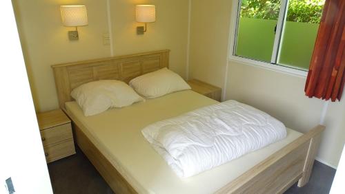a small bedroom with a bed with two pillows at Camping de Ikeleane in Bakkeveen