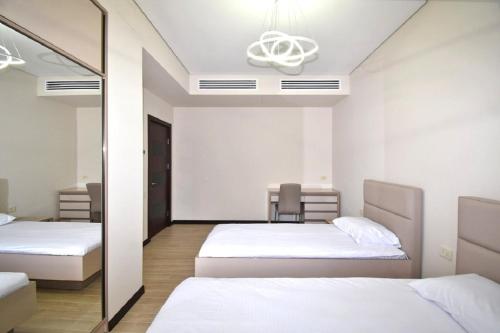 a bedroom with two beds and a mirror at Northern Avenue 2 bedrooms New and Modern apartment in New Elite Building HH600 in Yerevan