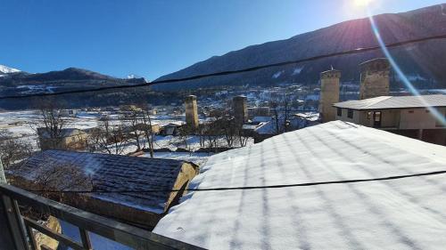 a snow covered roof of a building with the sun behind it at Mestia 4 season in Mestia
