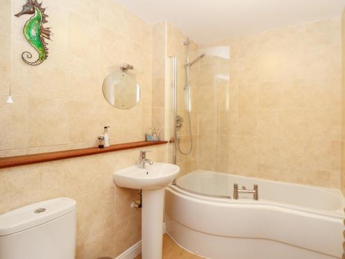 a bathroom with a sink and a tub and a toilet at Ocean Blue in Penzance
