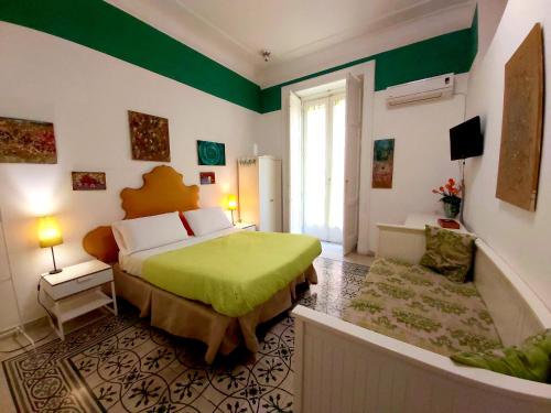 ein Schlafzimmer mit einem Bett und einer grünen Wand mit Akzenten in der Unterkunft B&B Platamon in Neapel