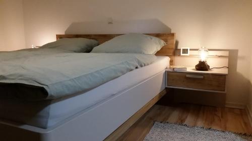 - une chambre avec un lit et une table de nuit avec une lampe dans l'établissement Neue Fewo in perfekter Lage (Limburg a. d. Lahn), à Limburg an der Lahn