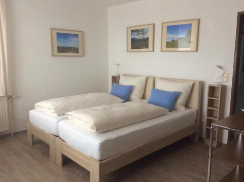 Bett in einem Zimmer mit blauen Kissen darauf in der Unterkunft Ferienwohnungen Kössl in Waidhofen an der Ybbs