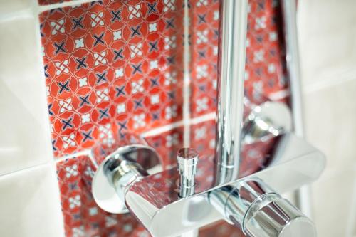 a bathroom with a sink and a mirror and tiles at Hotel****Spa & Restaurant Cantemerle in Vence