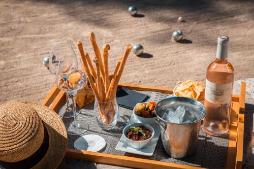 a table with a bottle of wine and wine glasses at Hotel****Spa & Restaurant Cantemerle in Vence