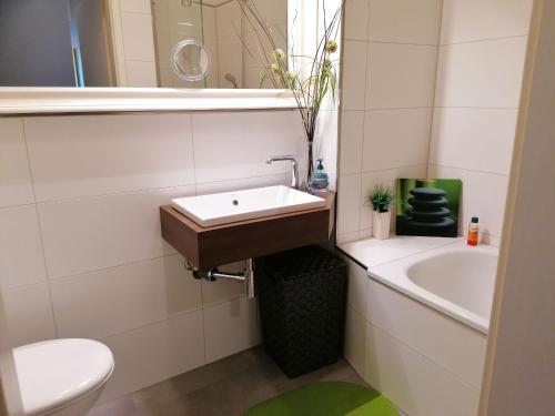 a bathroom with a sink and a toilet and a tub at Apartment New York in Mühlhausen