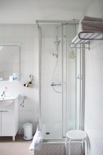 a bathroom with a shower and a sink at JFK Hotel Zelzate - Gent in Zelzate