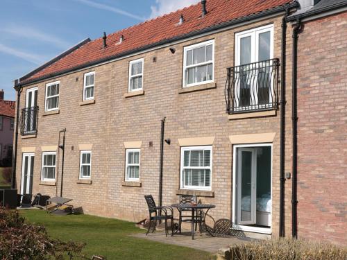 a brick house with a table and chairs in front of it at Denby Escape in Filey