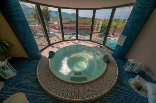 a jacuzzi tub in a room with a large window at Valtur Il Cormorano Resort & Spa in Grisolia