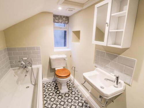 a bathroom with a toilet and a sink and a tub at Dovecote in Pickering