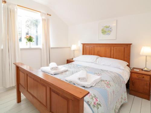 法爾茅斯的住宿－Tops'l Cottage，一间卧室配有一张床,上面有两条毛巾