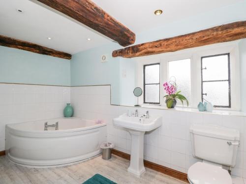 a bathroom with a tub and a sink and a toilet at Chapel House in Stonehouse