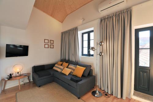 a living room with a couch and a tv at FLH Oporto Wine Cellars Luxury Apartment II in Vila Nova de Gaia