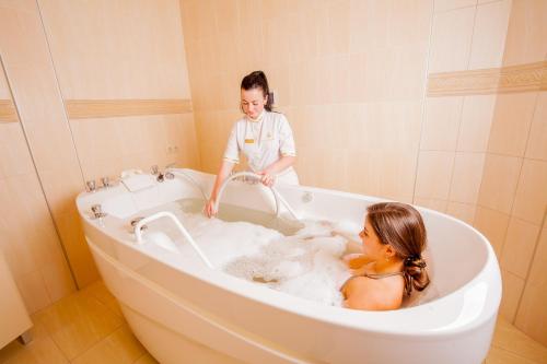 a woman in a bath tub with a girl in it at СПА-Готель "RESPECT" in Skhidnitsa