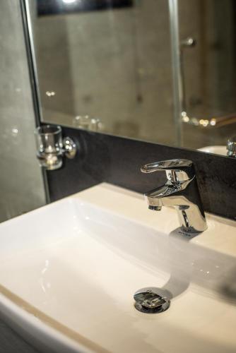 a bathroom sink with a faucet and a mirror at Kevans Casa in Mahiyangana
