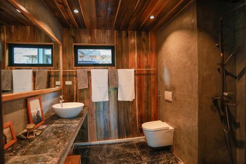 a wooden bathroom with a sink and a toilet at GISY Lake House 1F in Hanoi