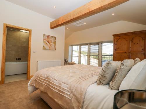 a bedroom with a large bed and a large window at The Hayloft in Harrogate